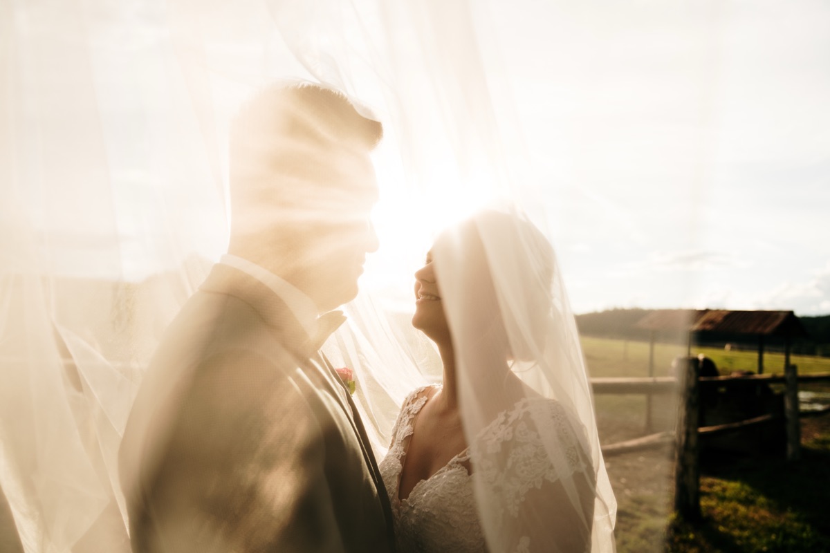 Novomanželé pod závojem v protisvětle – svatební fotograf Plzeň